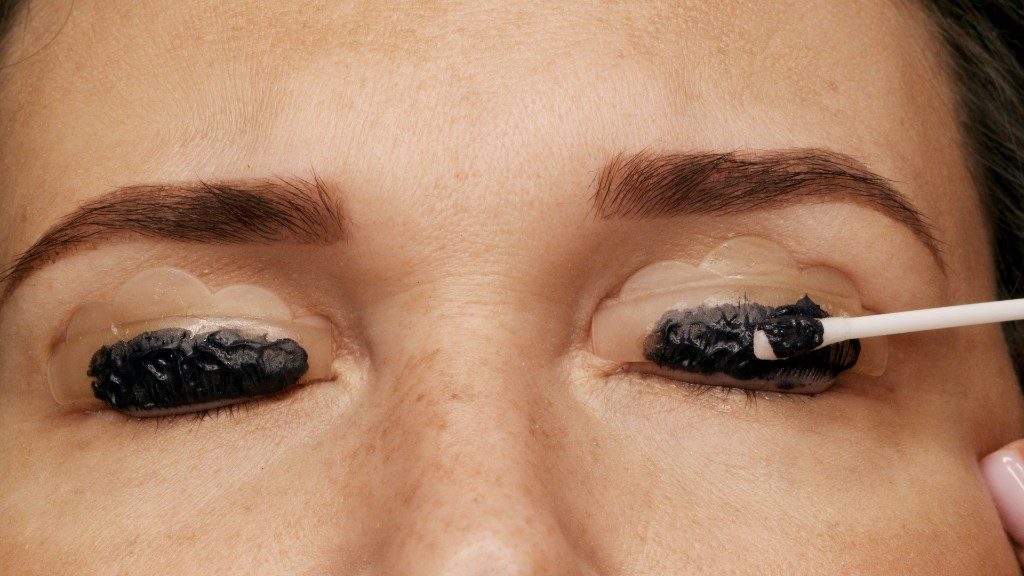Wimpernfarbe wird auf die eigenen Wimpern auf Silikonpads aufgetragen