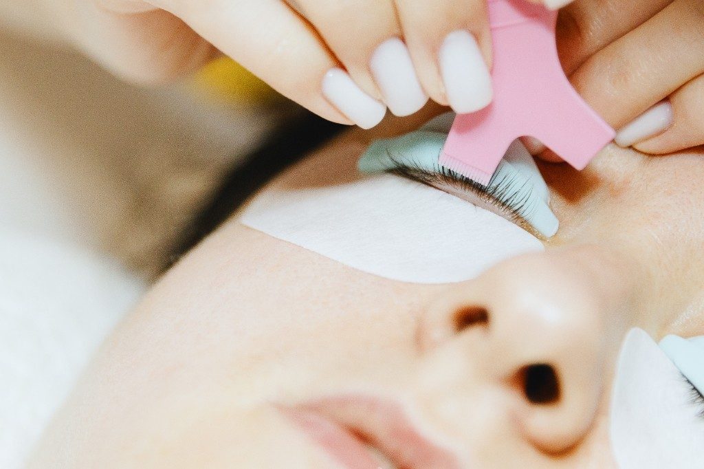 Wimpern werden mit einem Kamm auf dem Silikonpad ausgerichtet